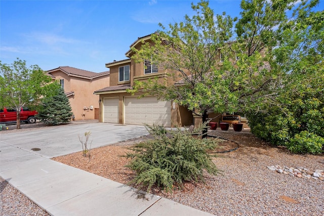 2613 Camino Catalonia, Rio Rancho, NM 87124 - view of front facade with stucco siding, driveway, a tiled roof, and a garage