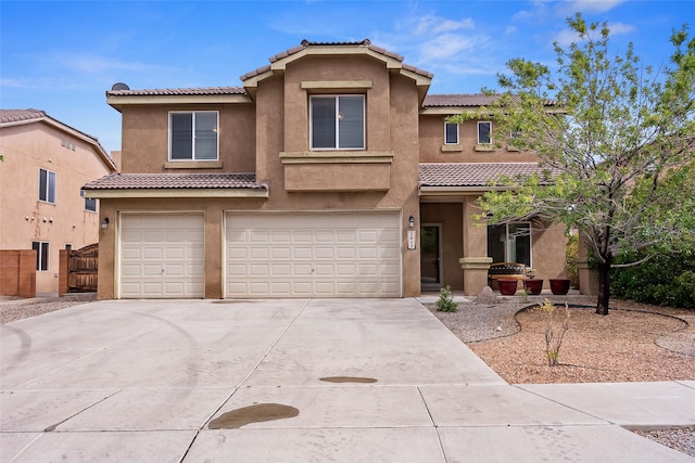 2613 Camino Catalonia, Rio Rancho, NM 87124 - view of front of home featuring a tiled roof, an attached garage, concrete driveway, and stucco siding