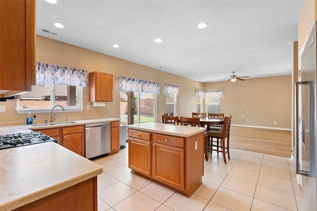 2613 Camino Catalonia, Rio Rancho, NM 87124 - kitchen with dishwasher, a sink, a ceiling fan, light countertops, and a textured ceiling