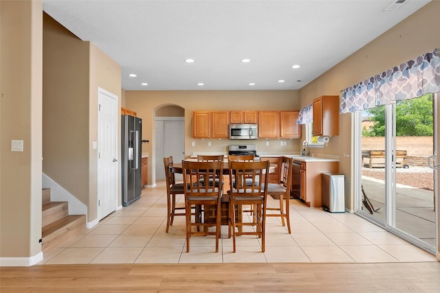 2613 Camino Catalonia, Rio Rancho, NM 87124 - dining area with arched walkways, recessed lighting, light tile patterned flooring, and baseboards