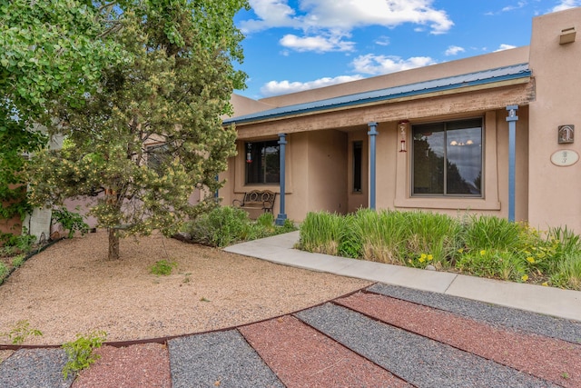 3 Periwinkle Pl, Santa Fe, NM 87508 - doorway to property with stucco siding and metal roof
