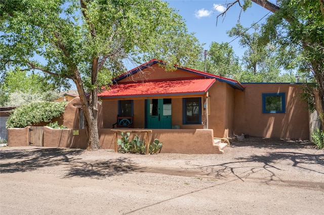 3 Waldo, Cerrillos, NM 87010 - view of front of house featuring covered porch, stucco siding, and metal roof