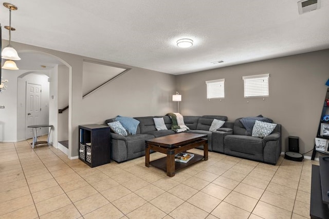 6280 Nardos Rd NW, Albuquerque, NM 87114 - living room with arched walkways, light tile patterned flooring, and stairway
