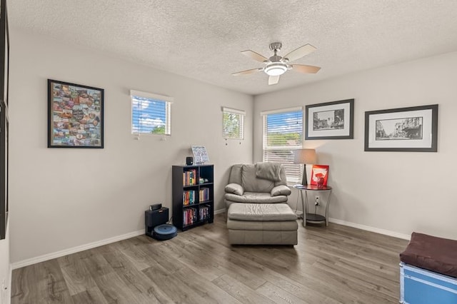 6280 Nardos Rd NW, Albuquerque, NM 87114 - living area with wood finished floors, a ceiling fan, healthy amount of natural light, a textured ceiling, and baseboards