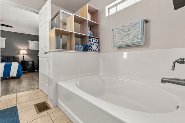6280 Nardos Rd NW, Albuquerque, NM 87114 - ensuite bathroom with a bath, tile patterned flooring, and a textured ceiling