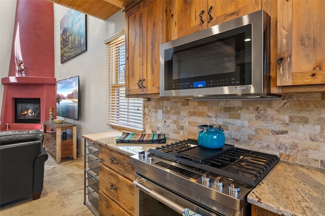 505 Juniper Dr Unit B, Santa Fe, NM 87501 - kitchen with stainless steel appliances, backsplash, brown cabinets, light stone counters, and wood ceiling