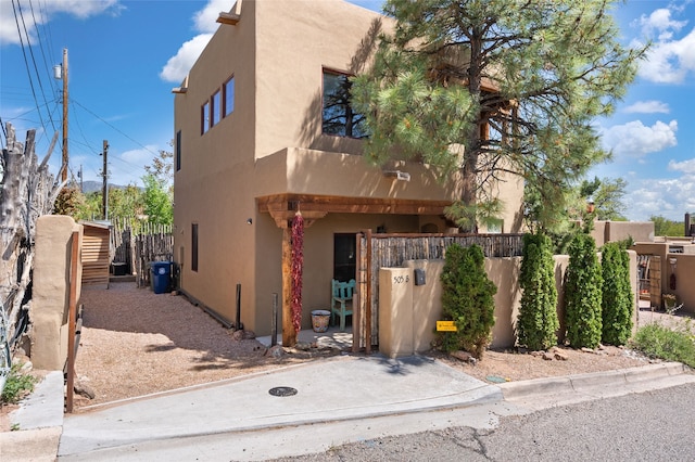 505 Juniper Dr Unit B, Santa Fe, NM 87501 - view of front of house with stucco siding, a fenced front yard, and a gate
