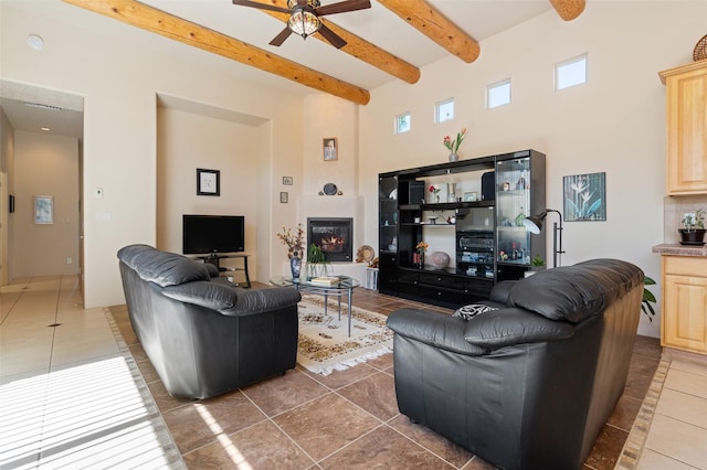 15 Cimarron Pass, Santa Fe, NM 87508 - tiled living room with a ceiling fan, a high ceiling, beam ceiling, and a glass covered fireplace