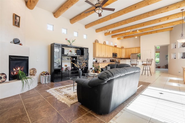 15 Cimarron Pass, Santa Fe, NM 87508 - living area featuring a towering ceiling, ceiling fan, light tile patterned floors, beamed ceiling, and a large fireplace