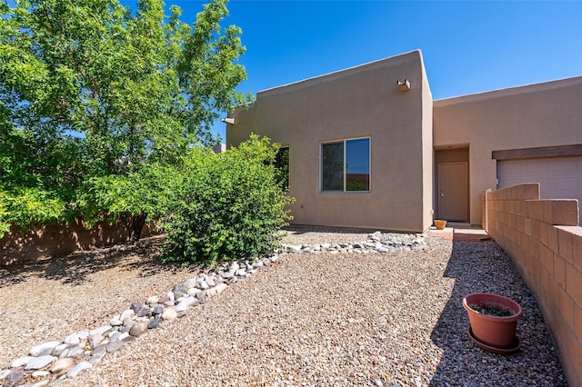 15 Cimarron Pass, Santa Fe, NM 87508 - rear view of house featuring stucco siding and an attached garage