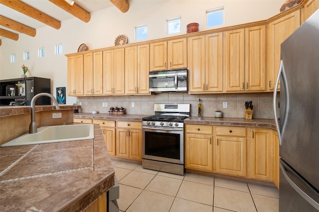 15 Cimarron Pass, Santa Fe, NM 87508 - kitchen with stainless steel appliances, a sink, backsplash, light tile patterned floors, and beamed ceiling