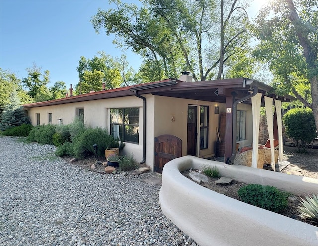 1402A Bishops Lodge Rd, Santa Fe, NM 87506 - view of front facade with stucco siding and a chimney
