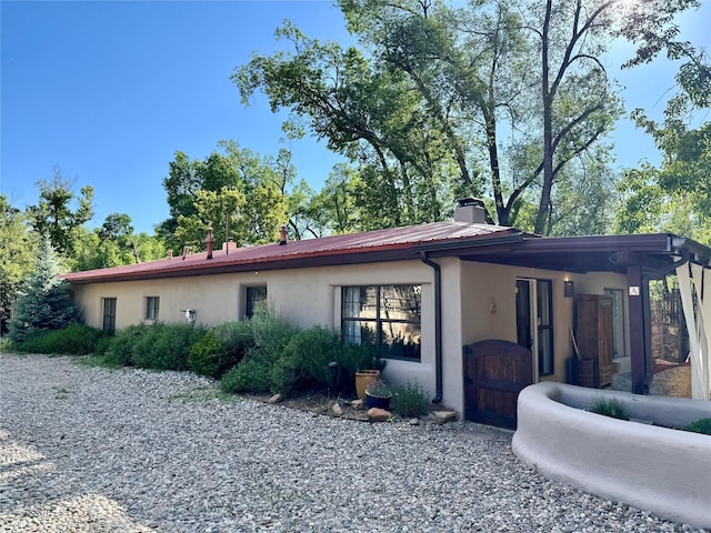 1402A Bishops Lodge Rd, Santa Fe, NM 87506 - view of side of property featuring a chimney and stucco siding