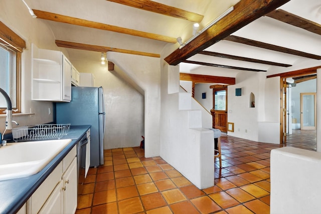 97 Quartz Trl, Santa Fe, NM 87505 - kitchen featuring beamed ceiling, white cabinets, open shelves, a sink, and light tile patterned floors