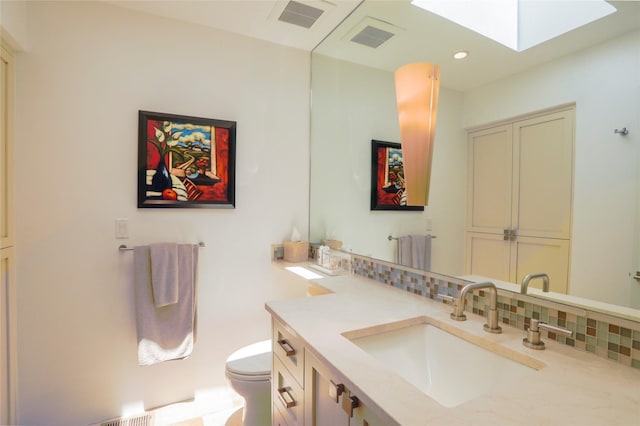 974 Old Santa Fe Trl, Santa Fe, NM 87505 - bathroom with vanity, a skylight, tasteful backsplash, and recessed lighting