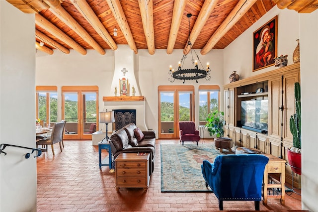 17 Alteza, Santa Fe, NM 87508 - living area featuring a wood ceiling with exposed beams, brick flooring, a high ceiling, a chandelier, and french doors