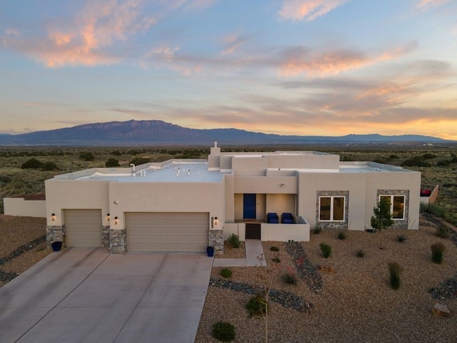 2324 Venada Rd, Rio Rancho, NM 87144 - pueblo-style house featuring a mountain view, an attached garage, and stucco siding
