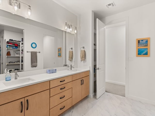 2324 Venada Rd, Rio Rancho, NM 87144 - full bathroom with double vanity, marble look tile flooring, and a spacious closet