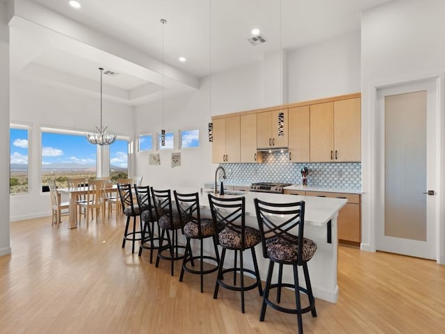 2324 Venada Rd, Rio Rancho, NM 87144 - kitchen featuring light wood-type flooring, a kitchen breakfast bar, light countertops, recessed lighting, and tasteful backsplash