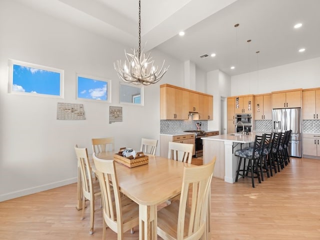 2324 Venada Rd, Rio Rancho, NM 87144 - dining area featuring a chandelier, light wood finished floors, recessed lighting, and a high ceiling