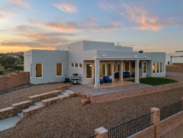 2324 Venada Rd, Rio Rancho, NM 87144 - back of house at dusk featuring an outdoor hangout area, stucco siding, a patio, and a fenced backyard