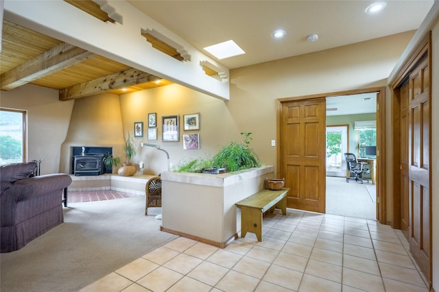 131 Quintana Rd, Questa, NM 87556 - entryway with light colored carpet, a wood stove, recessed lighting, light tile patterned flooring, and a wood ceiling with exposed beams