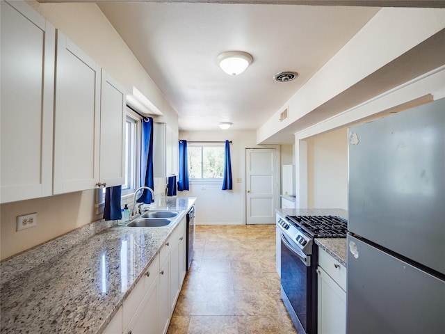 2148 33rd St Unit B, Los Alamos, NM 87544 - kitchen with appliances with stainless steel finishes, white cabinets, and light stone counters