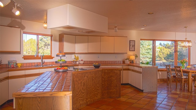 7 Paseo De Rincon, Santa Fe, NM 87508 - kitchen featuring a textured ceiling, white cabinetry, a peninsula, plenty of natural light, and recessed lighting