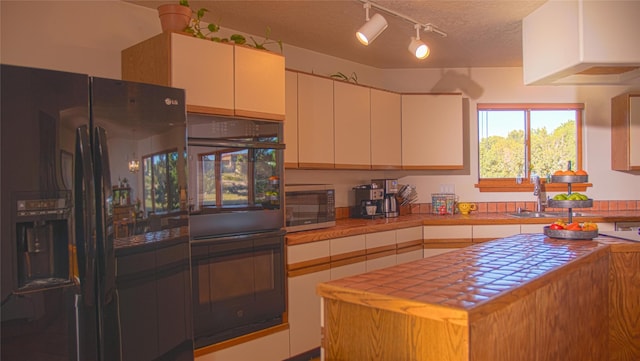 7 Paseo De Rincon, Santa Fe, NM 87508 - kitchen with black appliances, tile counters, a textured ceiling, track lighting, and white cabinets