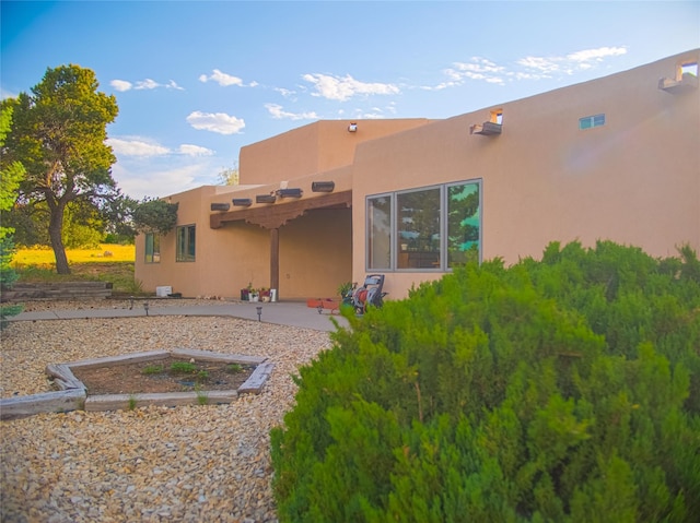7 Paseo De Rincon, Santa Fe, NM 87508 - back of house featuring stucco siding and a patio area