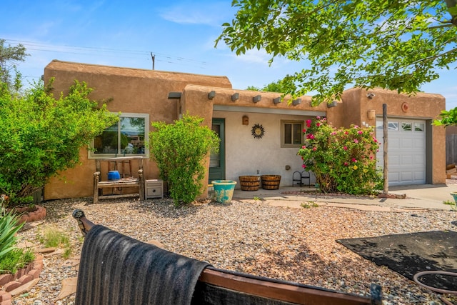 1361 Acequia Borrada, Santa Fe, NM 87507 - pueblo-style home featuring an attached garage, stucco siding, and driveway