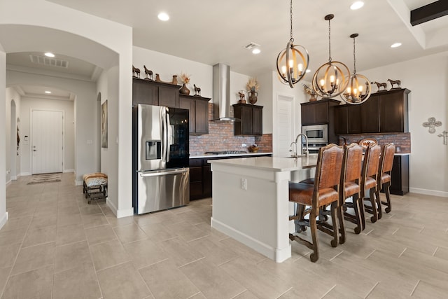 6816 Cleary Loop NE, Rio Rancho, NM 87144 - kitchen featuring appliances with stainless steel finishes, island exhaust hood, arched walkways, a chandelier, and decorative backsplash