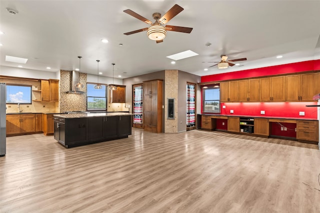 46 Oshara Blvd, Santa Fe, NM 87508 - kitchen with ceiling fan, a skylight, wall chimney exhaust hood, open shelves, and recessed lighting