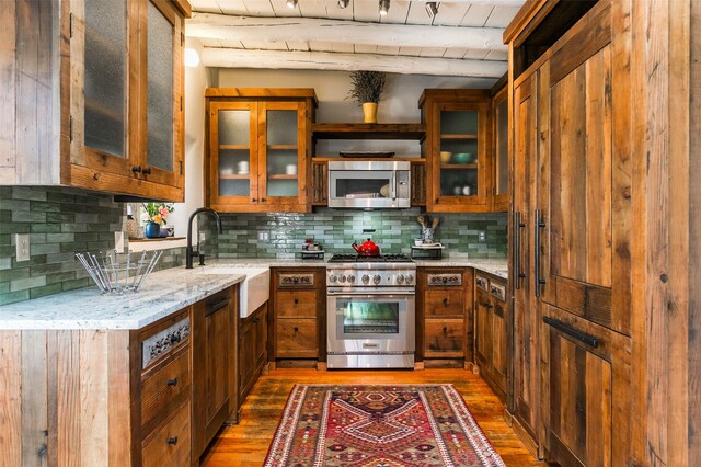 576 Camino Del Monte Sol, Santa Fe, NM 87505 - kitchen featuring stainless steel appliances, brown cabinetry, dark wood-style flooring, and light stone counters