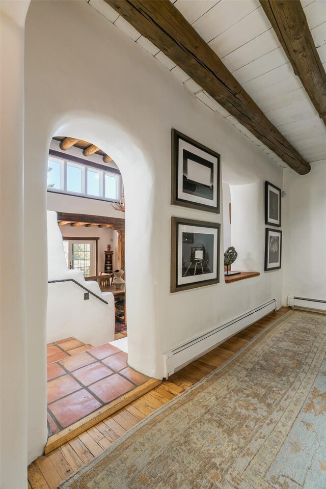 576 Camino Del Monte Sol, Santa Fe, NM 87505 - hallway featuring a baseboard radiator, arched walkways, hardwood / wood-style flooring, and beamed ceiling