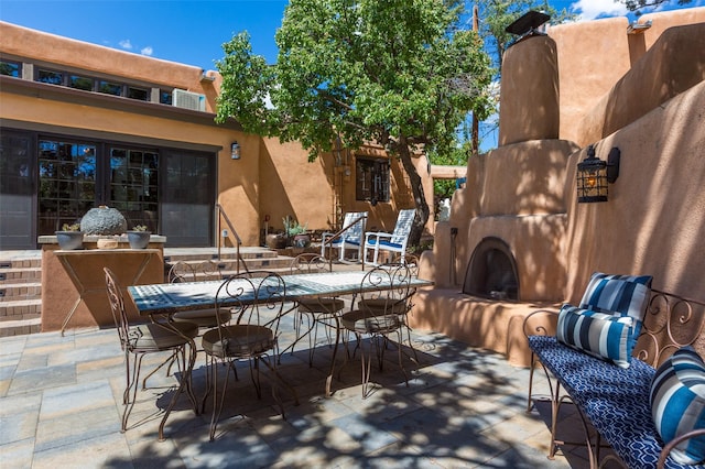 576 Camino Del Monte Sol, Santa Fe, NM 87505 - view of patio / terrace with exterior fireplace and outdoor dining space