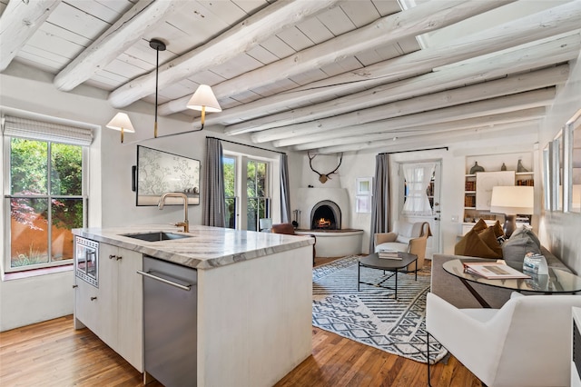 507 Acequia Madre, Santa Fe, NM 87505 - kitchen with open floor plan, a wooden ceiling with exposed beams, stainless steel appliances, a lit fireplace, and an island with sink