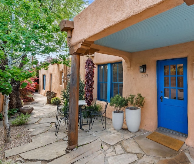 507 Acequia Madre, Santa Fe, NM 87505 - doorway to property with stucco siding, a patio area, and outdoor dining area