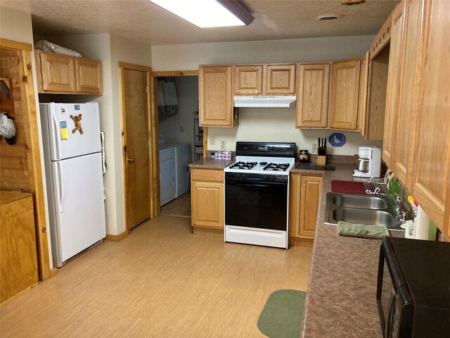 9 Bear Rd, Chama, NM 87520 - kitchen with freestanding refrigerator, gas range, under cabinet range hood, light wood-style floors, and washer and clothes dryer