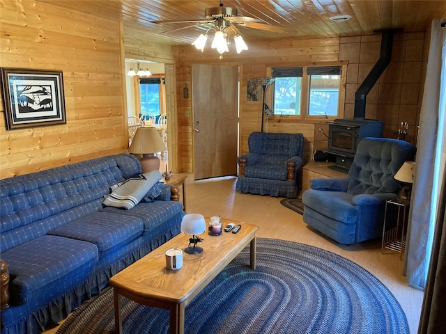 9 Bear Rd, Chama, NM 87520 - living room featuring wooden walls, a wood stove, ceiling fan, wood finished floors, and wooden ceiling