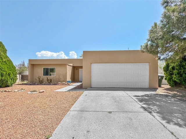 3301 Camino Prado Vis, Santa Fe, NM 87507 - pueblo-style home with stucco siding, concrete driveway, and an attached garage