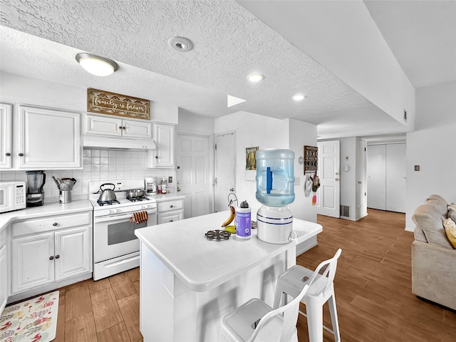 3301 Camino Prado Vis, Santa Fe, NM 87507 - kitchen featuring white appliances, a textured ceiling, white cabinets, light countertops, and light wood-style floors