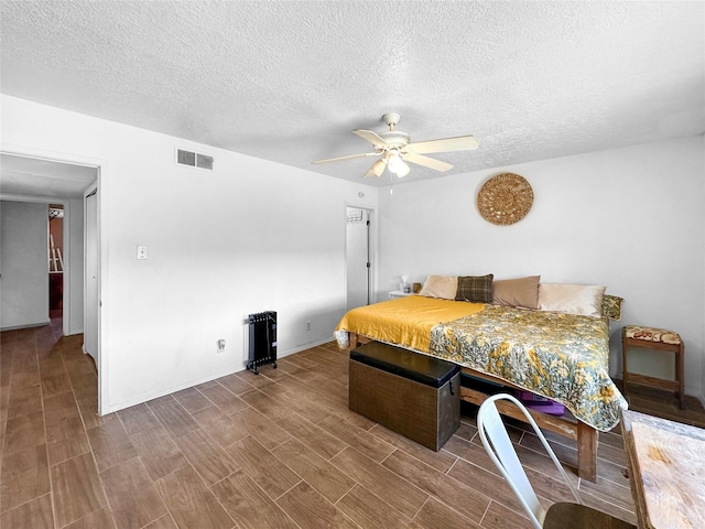 3301 Camino Prado Vis, Santa Fe, NM 87507 - bedroom with a textured ceiling, wood finished floors, and ceiling fan