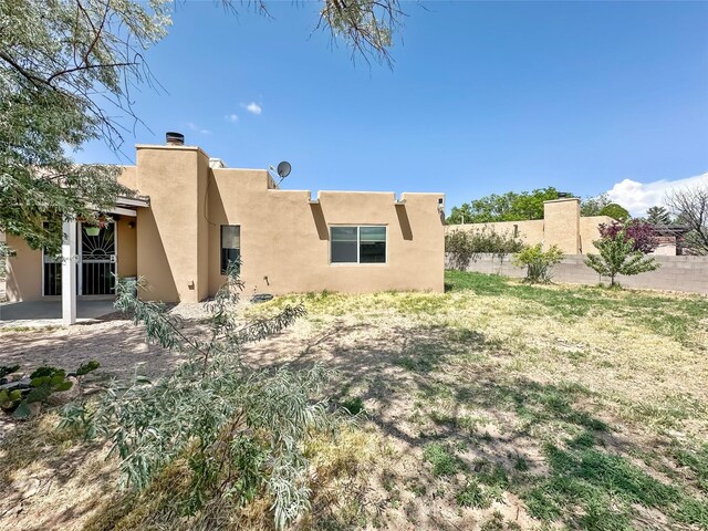 3301 Camino Prado Vis, Santa Fe, NM 87507 - rear view of property with stucco siding and a chimney
