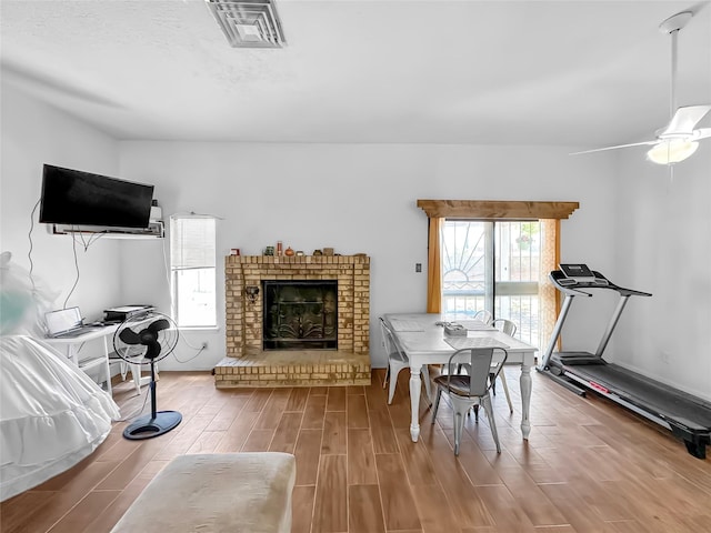 3301 Camino Prado Vis, Santa Fe, NM 87507 - dining area with wood finished floors, a fireplace, and a ceiling fan