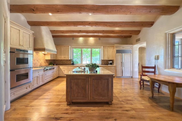 11 E Golden Eagle Rd, Santa Fe, NM 87506 - kitchen with appliances with stainless steel finishes, premium range hood, beam ceiling, arched walkways, and backsplash