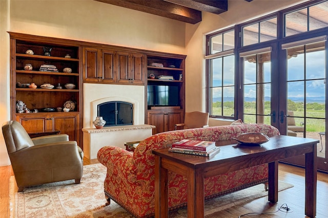 11 E Golden Eagle Rd, Santa Fe, NM 87506 - living area with light wood-style floors, beam ceiling, a fireplace, and french doors