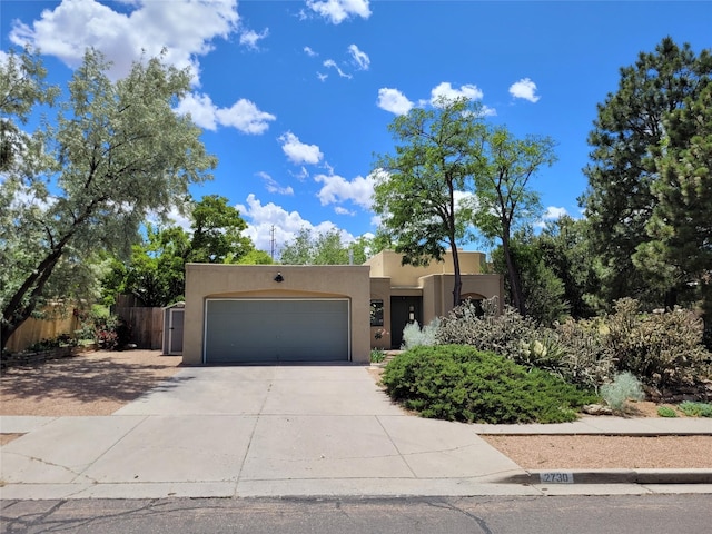 2730 La Silla Dorada, Santa Fe, NM 87505 - pueblo revival-style home with stucco siding, driveway, and an attached garage