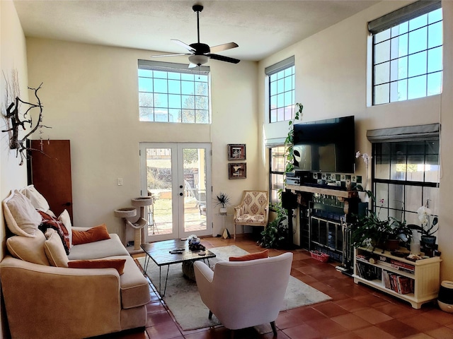 2730 La Silla Dorada, Santa Fe, NM 87505 - living room featuring ceiling fan, french doors, a glass covered fireplace, and a towering ceiling