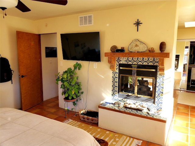 2730 La Silla Dorada, Santa Fe, NM 87505 - tiled bedroom with a tiled fireplace and a ceiling fan